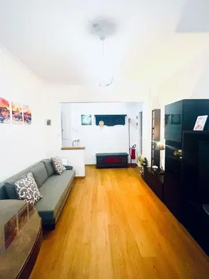 a living room with a couch and a wooden floor at Charming apartment Eur in Rome