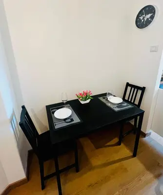 a black table with two glasses and flowers on it at Charming apartment Eur in Rome