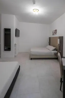a hotel room with two beds and a tv at Il Perugino Guest House in Rome