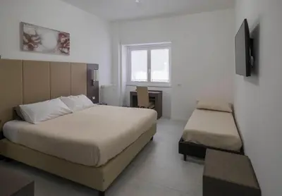 a bedroom with a bed and a desk and a window at Il Perugino Guest House in Rome