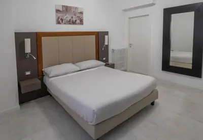 a bedroom with a bed and a mirror in it at Il Perugino Guest House in Rome