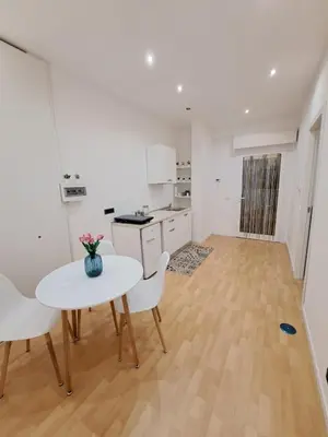 a white kitchen with a table and chairs and a table at TowerMorange in Rome