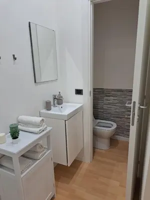 a white bathroom with a sink and a toilet at TowerMorange in Rome