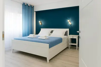 a bedroom with a large bed with a blue wall at Domus Tiber in Rome