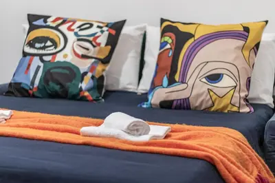 two beds with pillows and towels on top of them at San Giovanni Metro A Cozy Suite WIFI AC in Rome