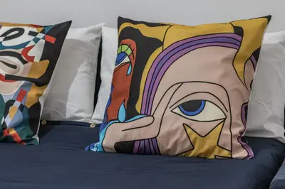 a bed with pillows with a painting of a woman at San Giovanni Metro A Cozy Suite WIFI AC in Rome