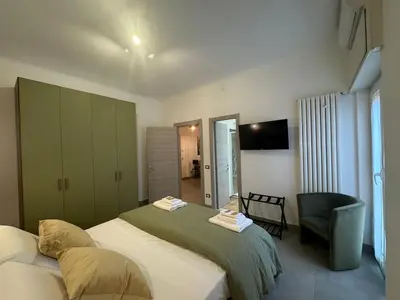 a hotel room with a bed and a chair at Grazia s Elegant Roman Haven with Terrace in Rome