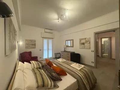 a bedroom with a bed and a chair in it at Grazia s Elegant Roman Haven with Terrace in Rome