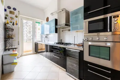 a kitchen with stainless steel appliances and blue cabinets at Romano Apartments - 