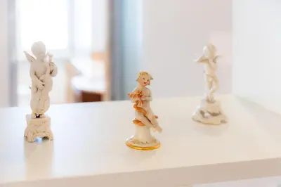 three miniature figurines sitting on a white shelf at Romano Apartments - 