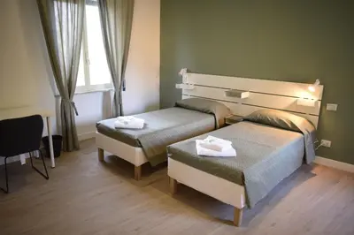 a hotel room with two beds and a window at Residenza Cimone in Rome