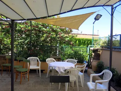 a patio with a table and chairs and an umbrella at Residenza Cimone in Rome