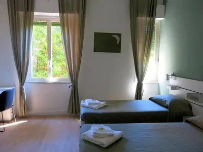 a small room with two beds and a window at Residenza Cimone in Rome