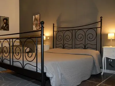 a bedroom with a black metal bed with white sheets at A Casa Di Giallo B&B in Rome