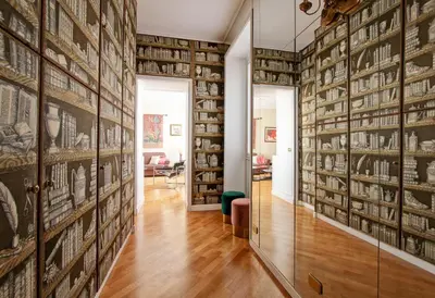 a hallway with a large wall of books at Roberta Apartment Fontana di Trevi in Rome