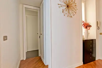a hallway with a white wall and a chandelier at Roberta Apartment Fontana di Trevi in Rome