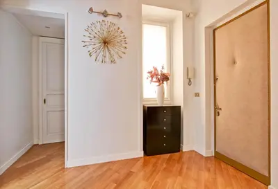 a hallway with a white wall and a chandelier at Roberta Apartment Fontana di Trevi in Rome