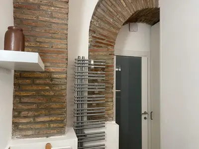 a brick wall in a kitchen with a spiral staircase at Divine Terrace Stylish Apartment St Peter Rome in Rome