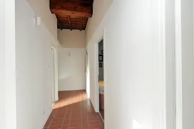 a hallway with a brick floor and white walls at Torre Argentina in Rome