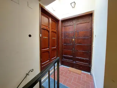 an empty room with wooden doors and a staircase at Torre Argentina in Rome