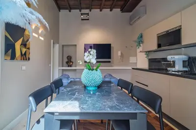 a dining room table with a vase of flowers on it at Dreamers in Belsiana Condotti Int 9 in Rome