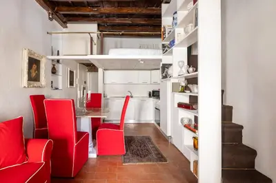 a kitchen with red chairs and a table in a room at Elegant Studio in the Center in Rome