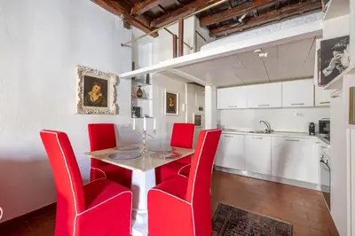 a dining room with red chairs and a table at Elegant Studio in the Center in Rome