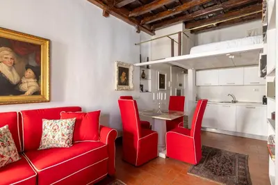 a living room with a red couch and a table at Elegant Studio in the Center in Rome