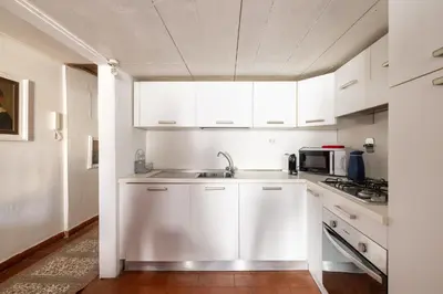 a white kitchen with a sink and a microwave at Elegant Studio in the Center in Rome