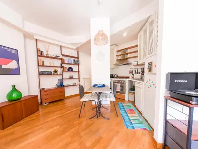 a living room with a table and a kitchen at Central Boutique Apartment for2 in Rome