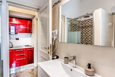 a bathroom with a sink and red cabinets at Apartment near Via Veneto in Rome