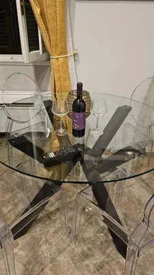 a glass table with a bottle of wine and wine glasses at Apartment near Via Veneto in Rome
