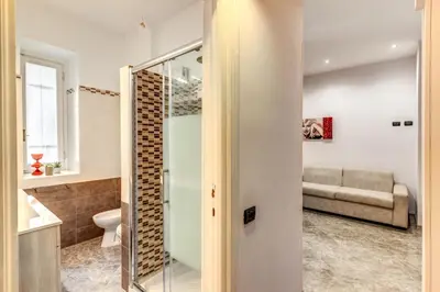 a bathroom with a shower and a couch in a room at Apartment near Via Veneto in Rome