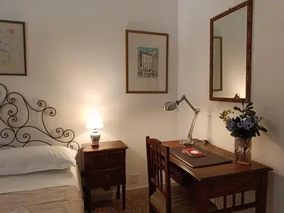 a bedroom with a bed and a desk with a lamp at Your window on San Pietro in Rome