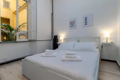 a large white bed in a room with a window at Elegant suite in Prati, 5 minutes from the Vatican in Rome