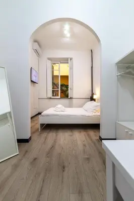 a white bedroom with a bed and a mirror at Elegant suite in Prati, 5 minutes from the Vatican in Rome
