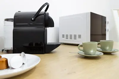 two coffee cups on a table next to a toaster at Elegant suite in Prati, 5 minutes from the Vatican in Rome