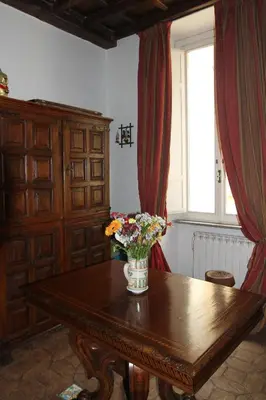 a vase of flowers on a wooden table with a window at Campo dei Fiori Jewel in Rome