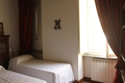 a bedroom with two beds and a cross on the wall at Campo dei Fiori Jewel in Rome
