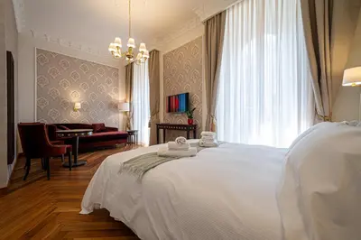 a bedroom with a large white bed and a desk at L'Angolo Sereno Guesthouse Rome Termini in Rome