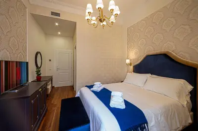 a bedroom with a large bed and a chandelier at L'Angolo Sereno Guesthouse Rome Termini in Rome