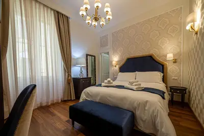 a bedroom with a large bed and a chandelier at L'Angolo Sereno Guesthouse Rome Termini in Rome