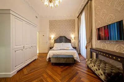 a bedroom with a bed and a chandelier at L'Angolo Sereno Guesthouse Rome Termini in Rome