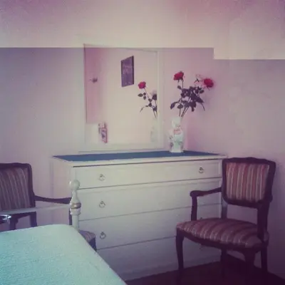 a bedroom with a dresser with flowers in a vase at Ipanema B&B in Rome