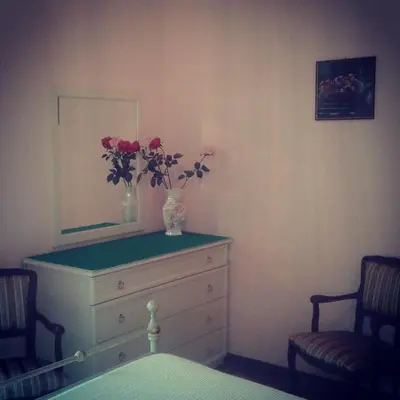 a bedroom with a dresser with a vase of flowers on it at Ipanema B&B in Rome