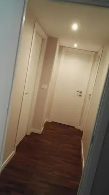 a hallway with a white door and a wooden floor at A Casetta Nostra in Rome