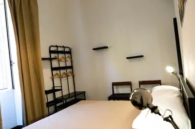 a bedroom with a bed and a shelf with shoes at ColosseoHome in Rome