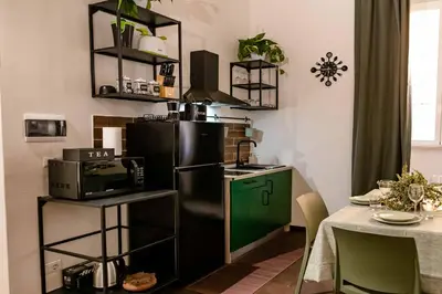 a kitchen with a black refrigerator freezer next to a table at ColosseoHome in Rome