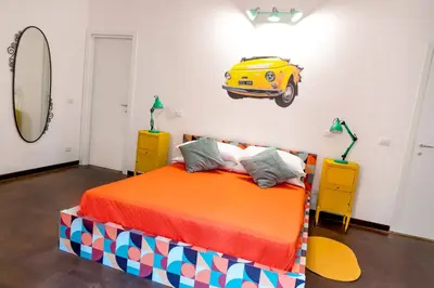a bedroom with a bed with a yellow car on the wall at ColosseoHome in Rome