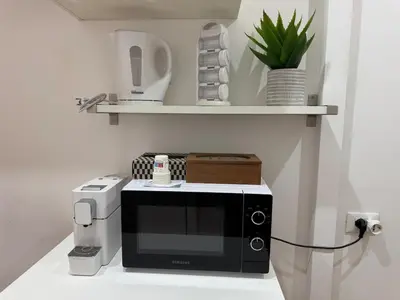 a microwave sitting on top of a counter next to aendar at DOMUS I Cozy Apt -20 min from Colosseum in Rome